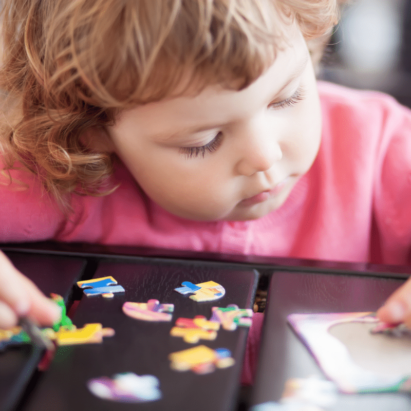 toddler child playing with a puzzle 
