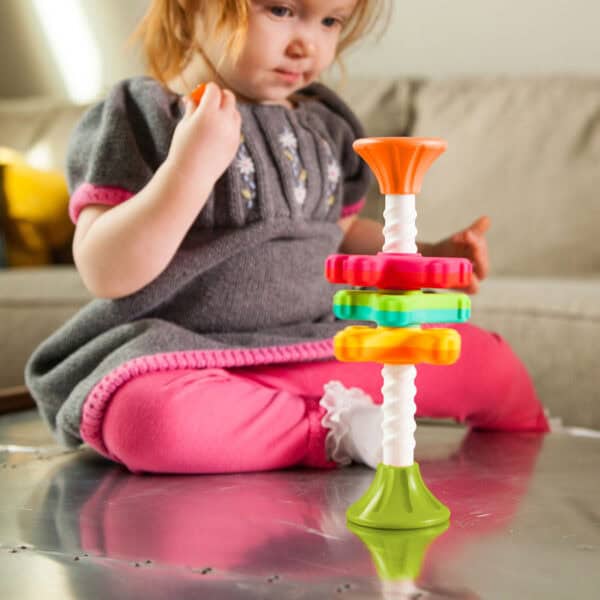 Toddler playing with colorful stacking toy