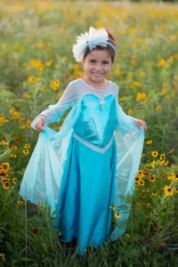 Child in blue dress in flower field