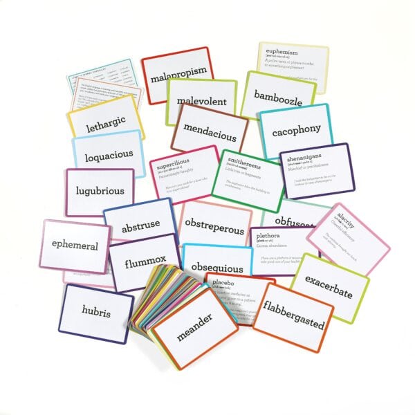 Colorful vocabulary flashcards scattered on a white surface.