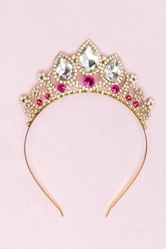 Sparkling jeweled tiara on soft pink background.