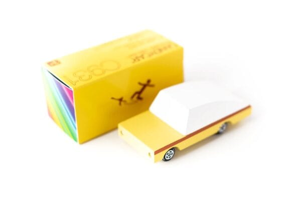 Yellow toy car with matching box on white background.