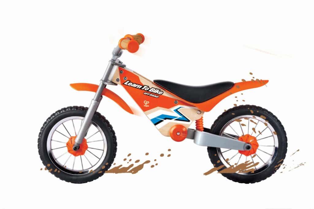 Orange children's balance bike with training wheels.