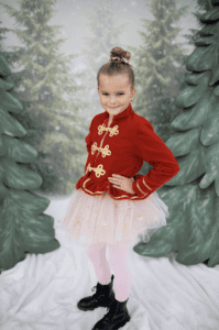 Child in festive costume with red jacket.