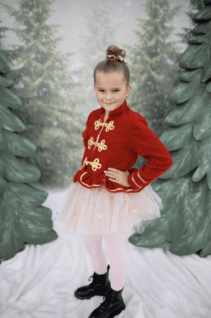 Child in festive costume with red jacket.