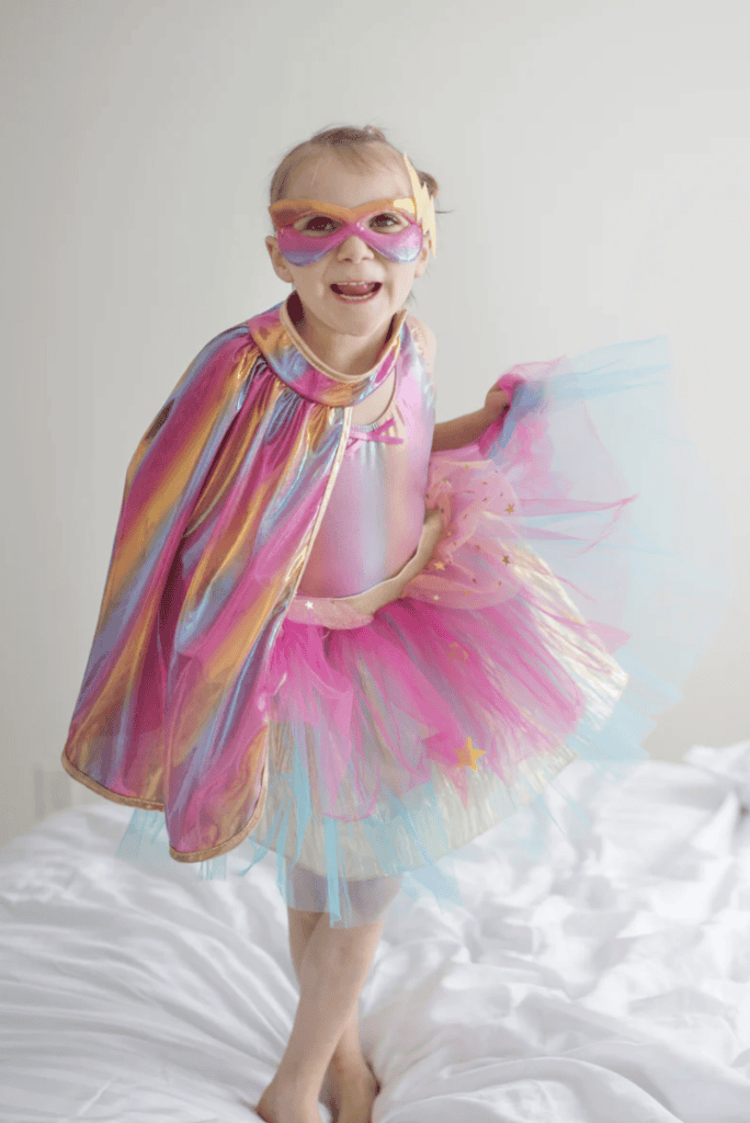 Child in colorful superhero costume smiling