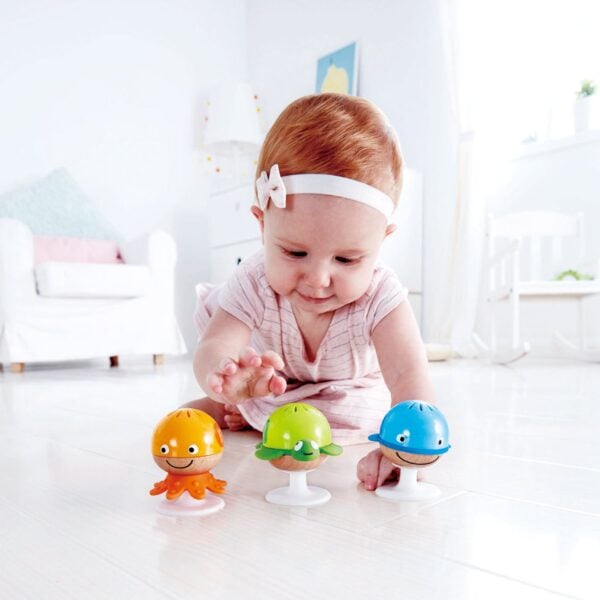 Baby playing with colorful toy animals.