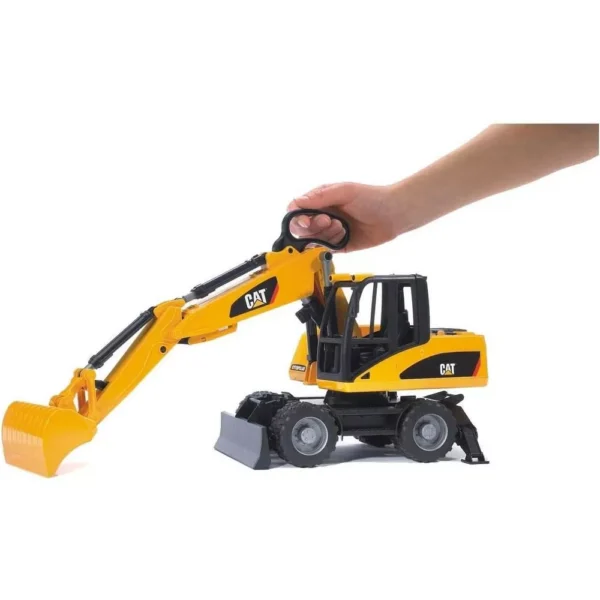Toy construction excavator held by a hand.