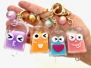 Colorful popsicle face keychains with smiling faces.