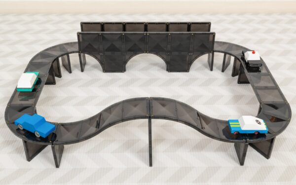 Toy cars on track with walls and ramps.