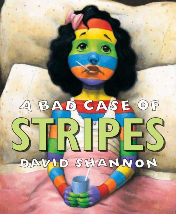 Girl with rainbow stripes in bed, holding mug