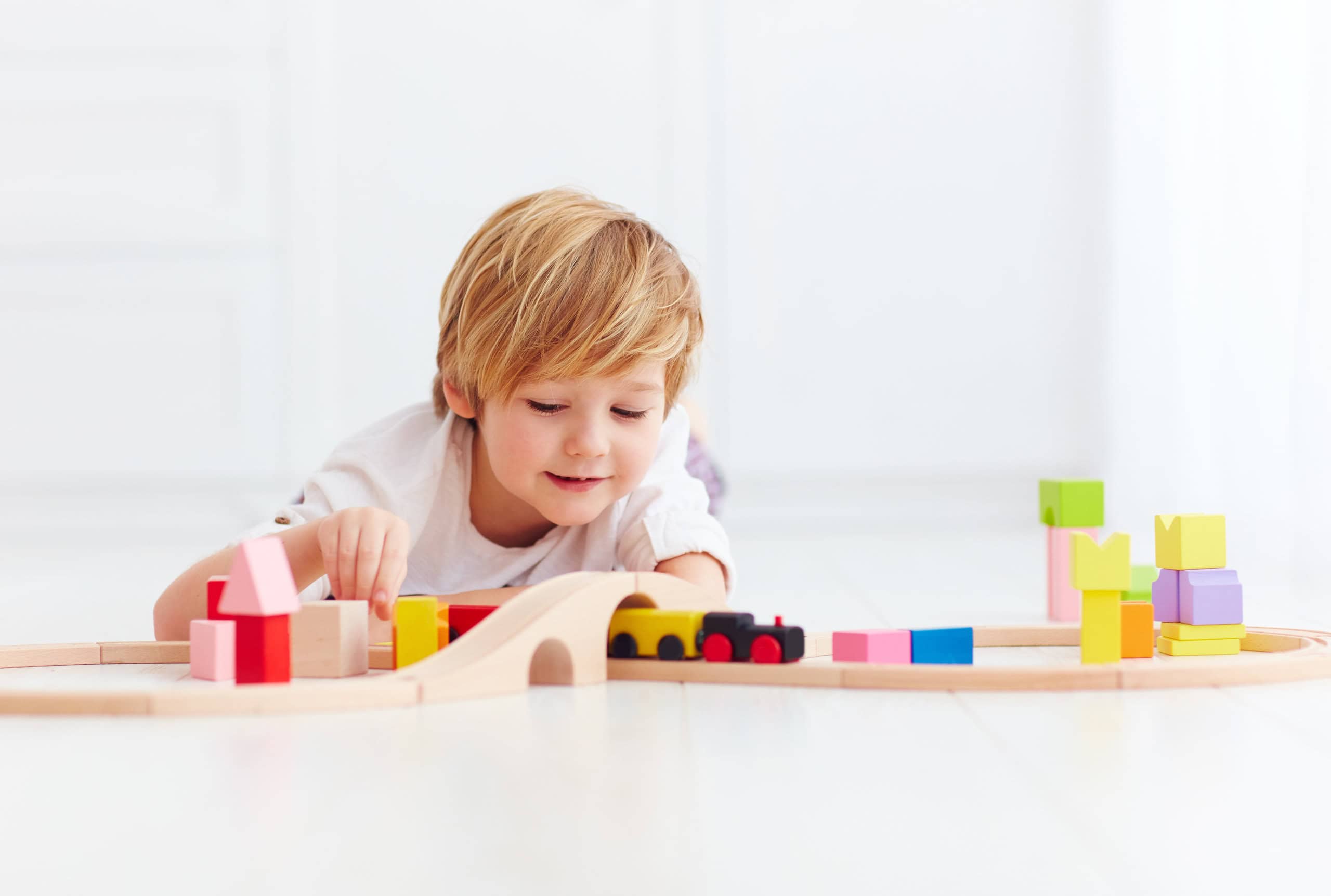 Child playing with wooden train set blocks
