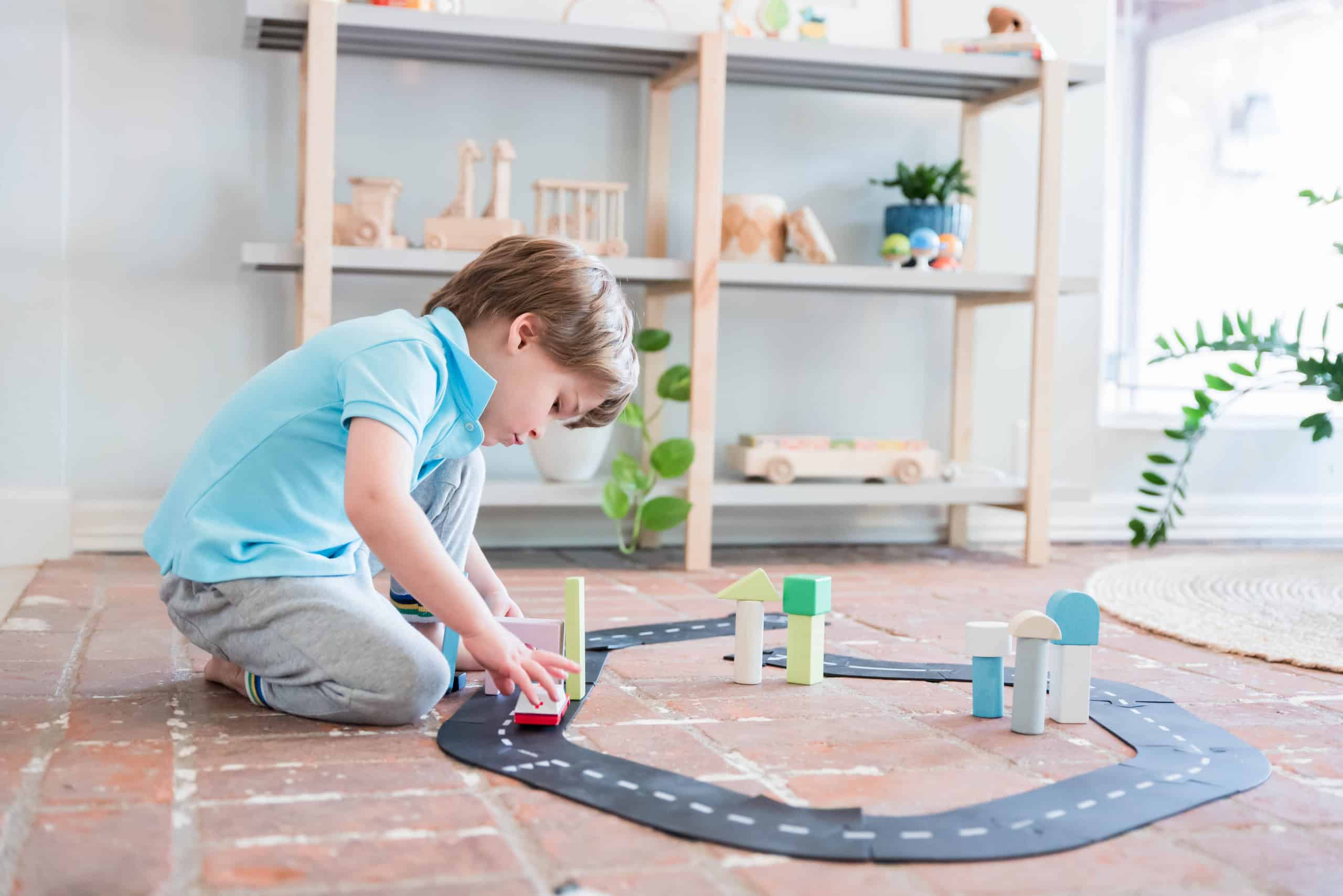Child playing with wooden blocks from Wildlings Toy Boutique