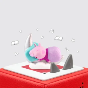 Toy pig sleeping on red speaker box