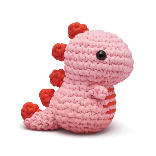 Pink crocheted dinosaur toy with red accents.