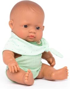 Realistic baby doll in green outfit sitting