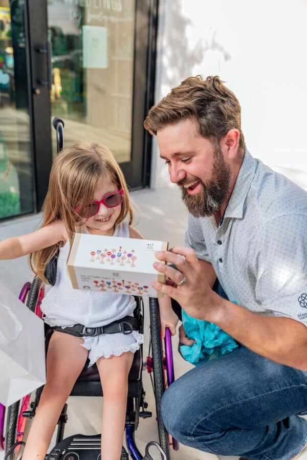 Man and girl smiling with toy box