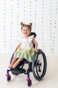 Smiling child in wheelchair with colorful backdrop
