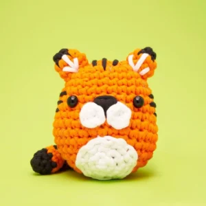Crocheted orange tiger on green background.