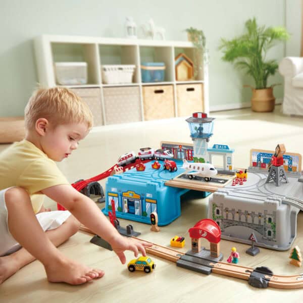 Child playing with toy city set on floor.