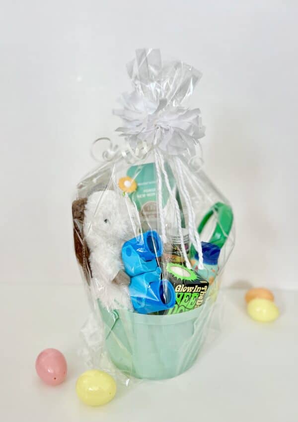Easter basket with toys and candy in plastic wrap.