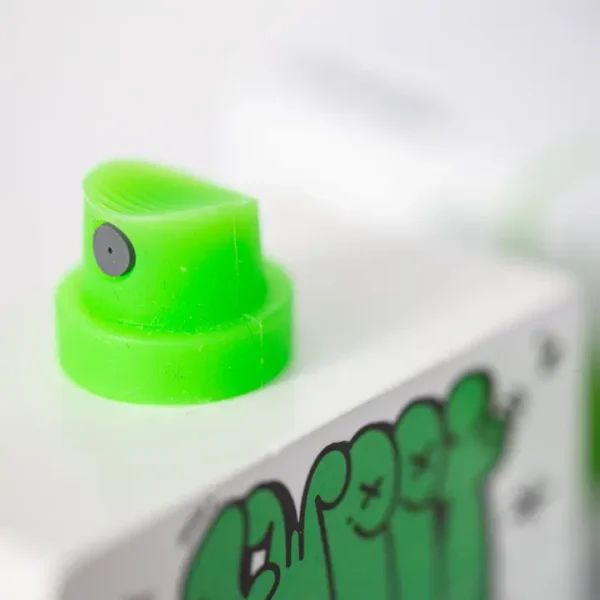 Close-up of green spray paint nozzle and graffiti.