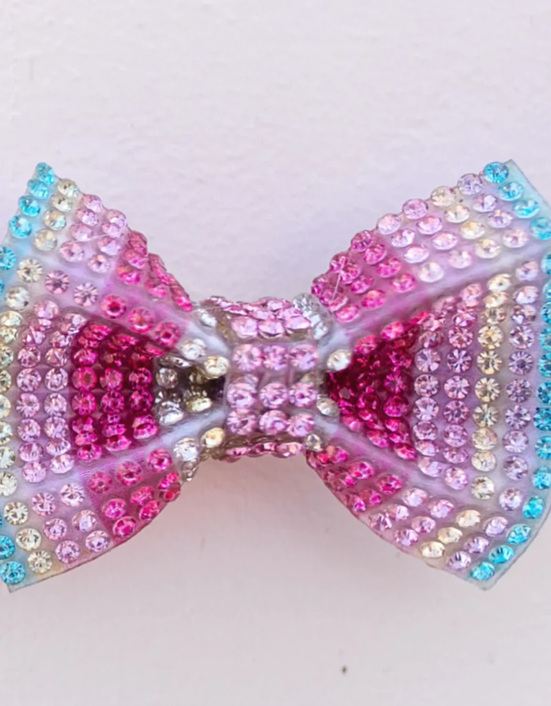 Colorful rhinestone bow against white background.