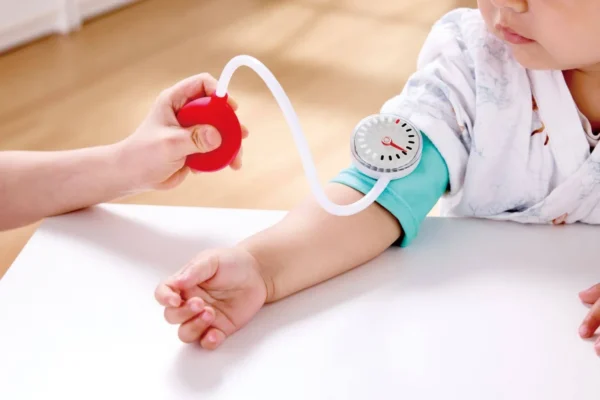 Child playing with toy blood pressure monitor.