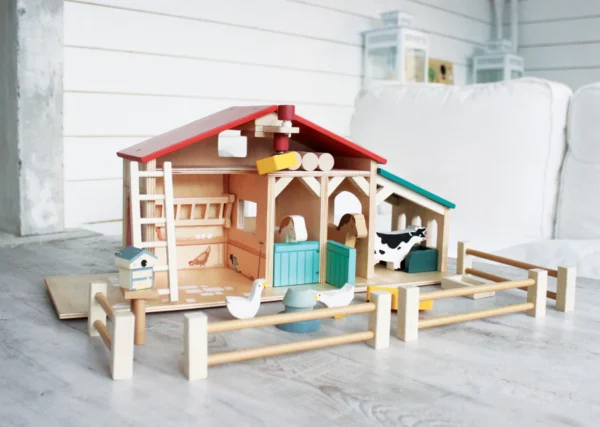 Wooden toy farm set with animals and barn.