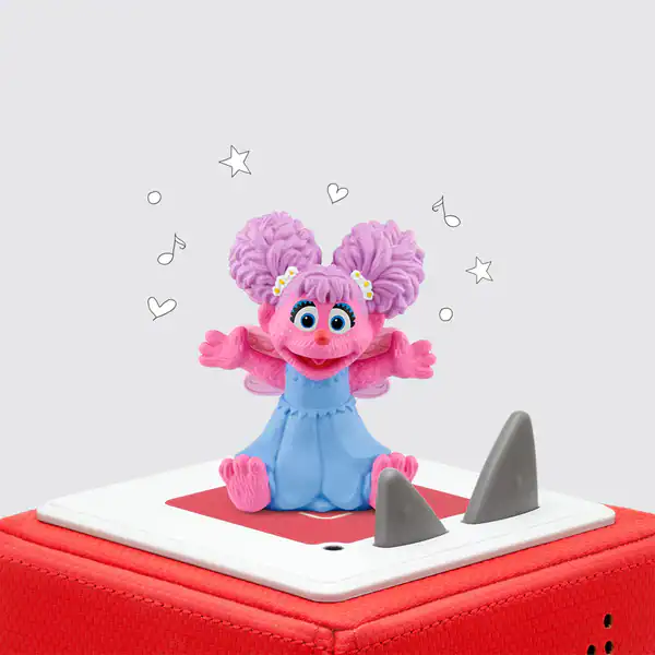 Cute pink doll on red speaker box