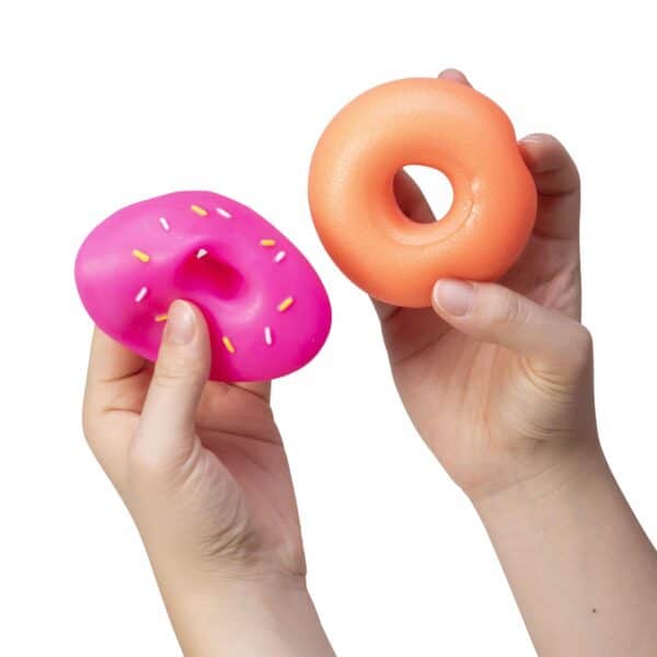 Hands holding pink and orange squishy toys.