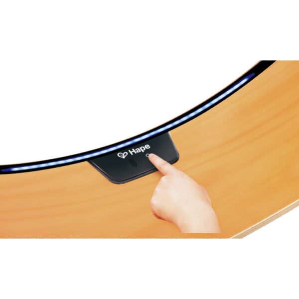 Finger pointing at Hape music button on table