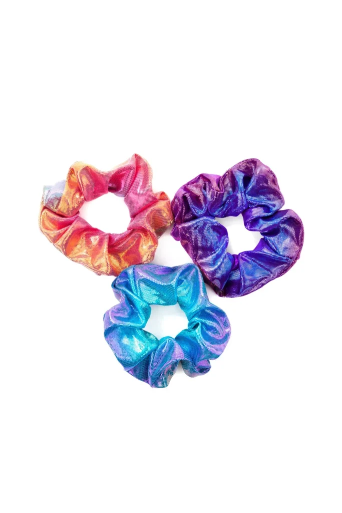 Three colorful satin scrunchies on white background.