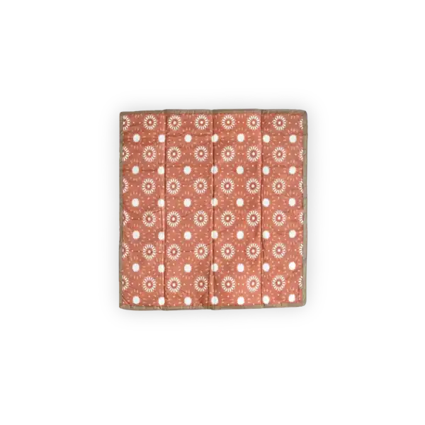 Red patterned quilt with white circular designs