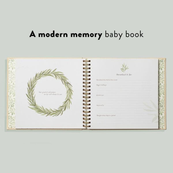 Open modern baby memory book with green wreath.
