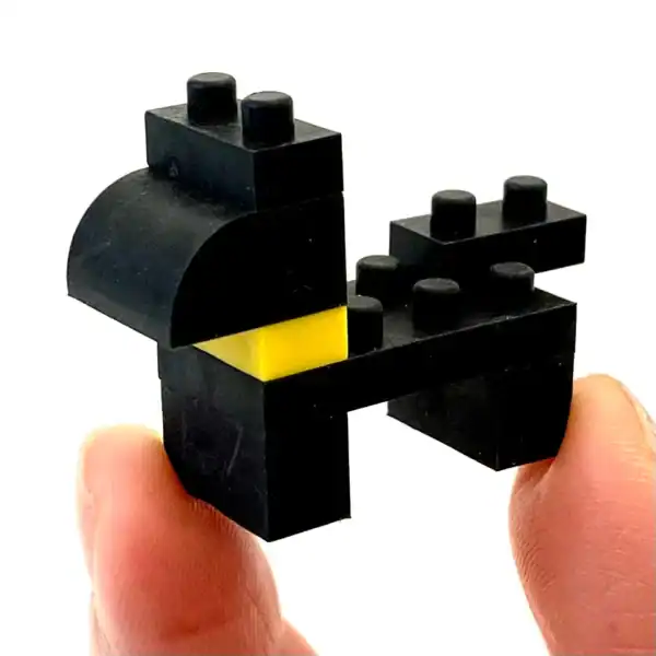 Black Lego chicken on fingers