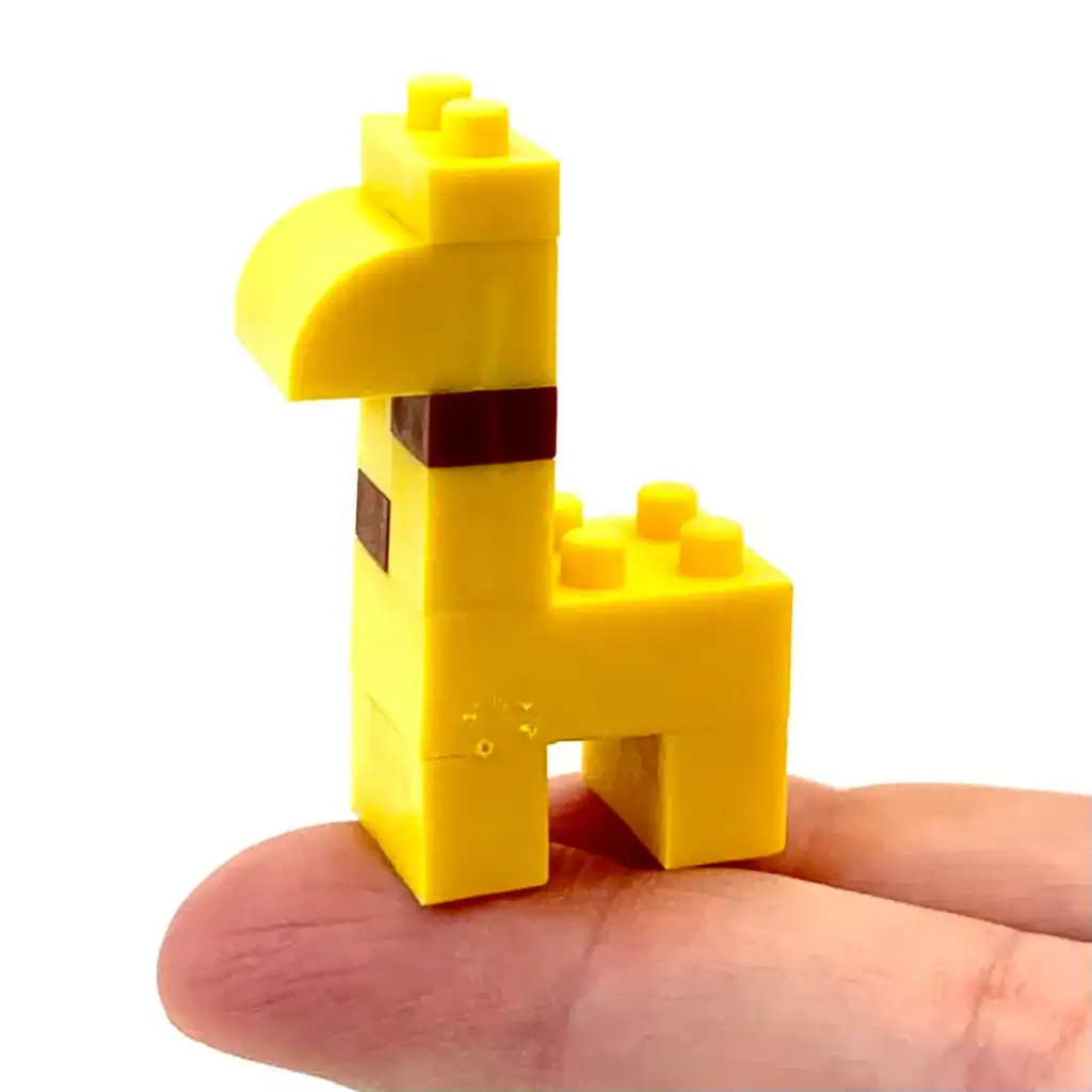Yellow block giraffe on a fingertip
