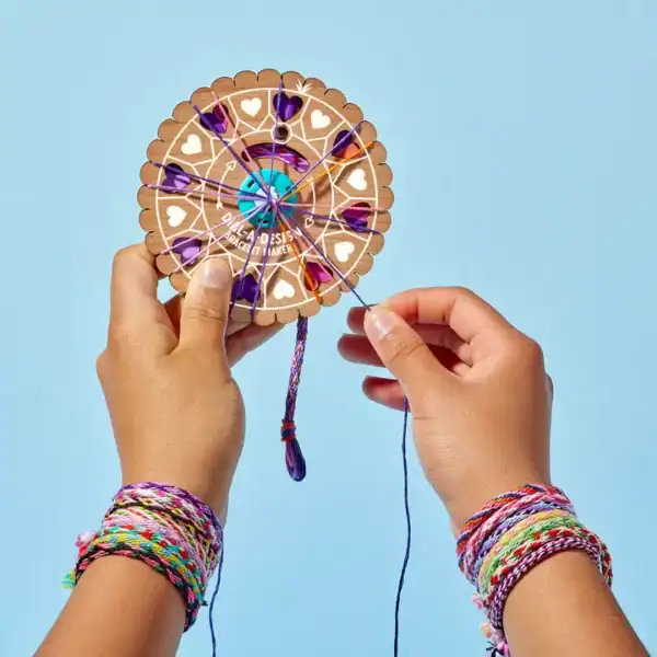 Person making a colorful friendship bracelet