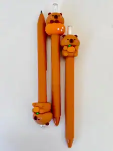 Three orange pens with cute bear designs.