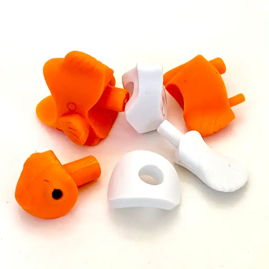 Disassembled toy chicken figure pieces on white background.