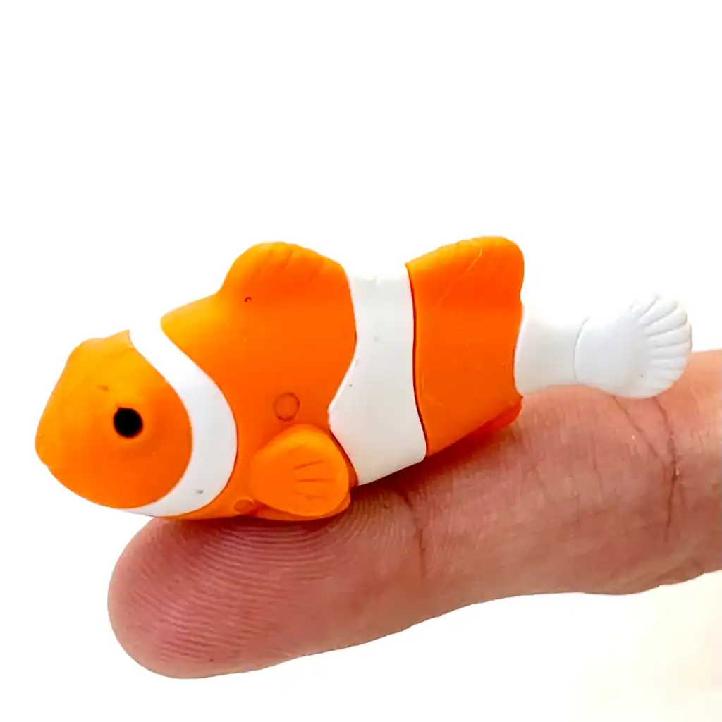 Toy clownfish resting on a fingertip.