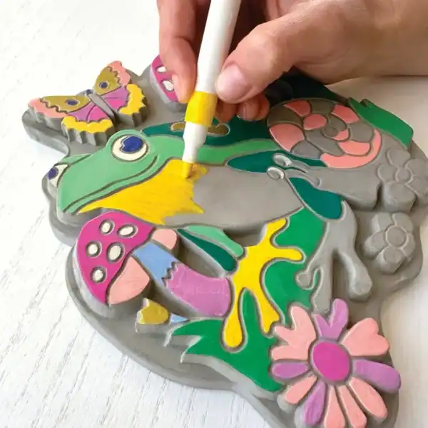 Colorful DIY stone painting with frog and flowers.