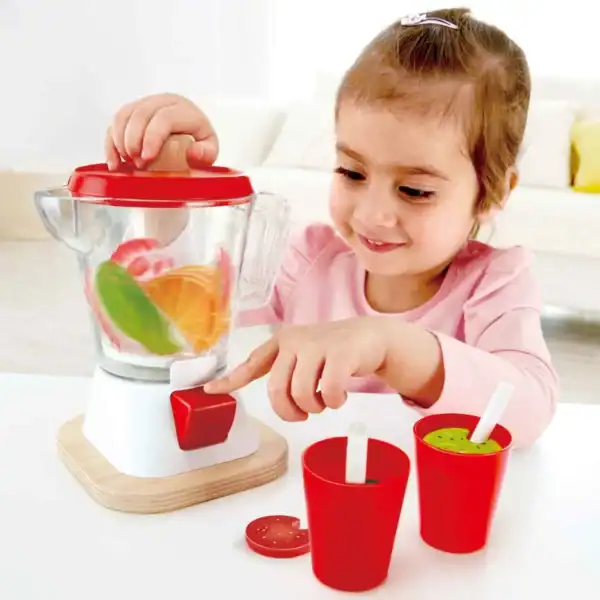 Child playing with toy blender and cups.