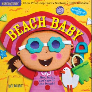 Smiling baby in sunglasses with beach toys.