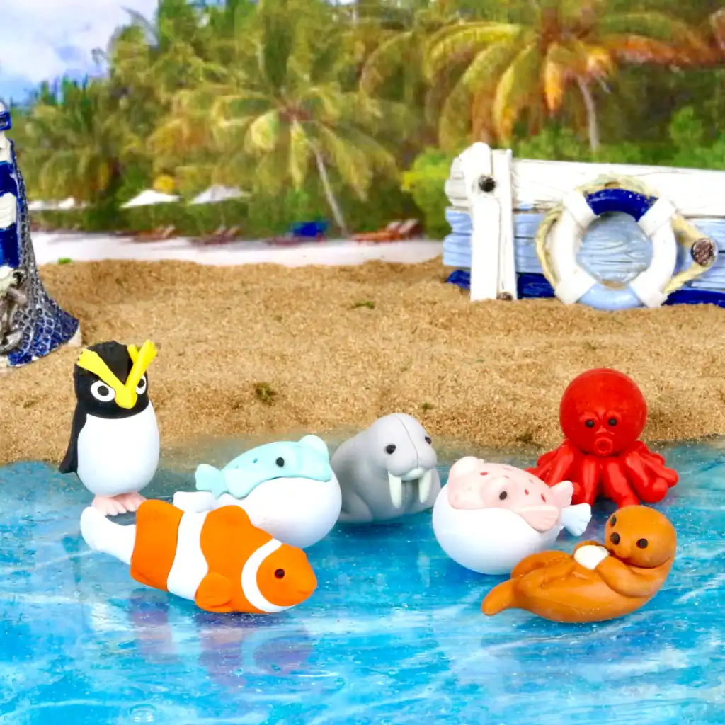 Colorful sea animal toys on beach backdrop.