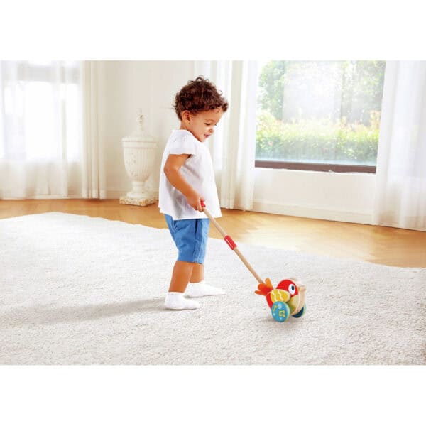 Child playing with wooden bird toy indoors.