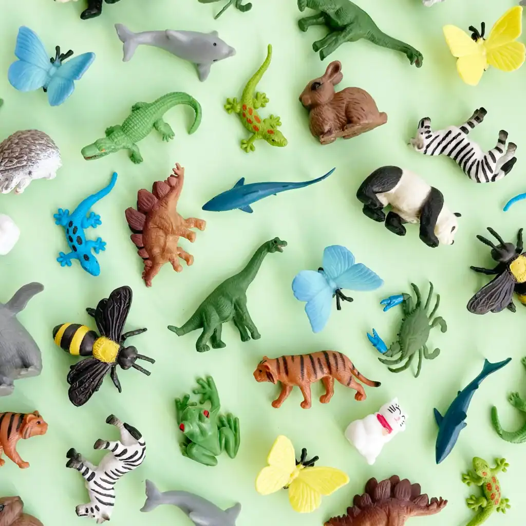 Colorful animal toys on green background