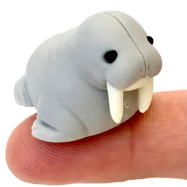 Small clay walrus figurine on fingertip