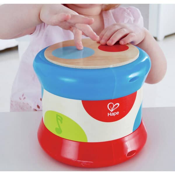 Child playing with colorful toy drum.