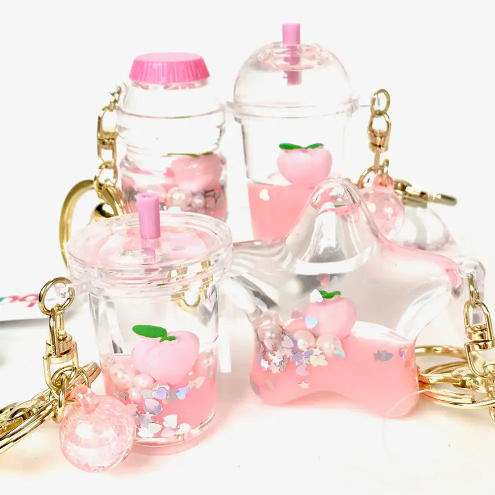 Pink peach-themed keychains with glittery liquid.